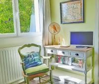 a room with a chair and a desk with a tv at Villa Saint Kirio - piscine et spa in Morlaix