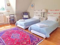 a bedroom with two beds and a table and a rug at Villa Saint Kirio - piscine et spa in Morlaix