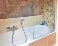 a bathroom with a tub with a shower at Villa Saint Kirio - piscine et spa in Morlaix