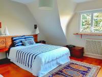 a bedroom with a bed with a blue and white blanket at Villa Saint Kirio - piscine et spa in Morlaix
