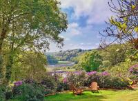 a park with a bench and flowers and a lake at Villa Saint Kirio - piscine et spa in Morlaix