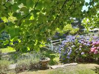 a white fence in a garden with flowers at Villa Saint Kirio - piscine et spa in Morlaix