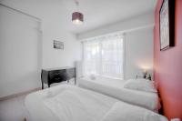 two beds in a room with a window at IMMOGROOM - Renovated apartment - Terrace - AC in Cannes