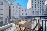 a balcony with a wooden table and two chairs at IMMOGROOM - Renovated apartment - Terrace - AC in Cannes