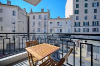 a wooden table and two chairs on a balcony at IMMOGROOM - Renovated apartment - Terrace - AC in Cannes