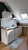 - une cuisine avec des placards blancs et un évier dans l&#39;établissement Appartement Vallée de la Risle, à Glos-sur-Risle