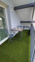 d&#39;une table et de chaises sur un balcon avec de l&#39;herbe verte dans l&#39;établissement Appartement Vallée de la Risle, à Glos-sur-Risle