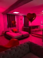 a pink room with two beds and a heart balloon at Suite Cupidon- Domaine des trois châteaux in Moisenay