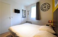 a bedroom with a bed and a clock on the wall at Awesome Apartment In quemauville With Outdoor Swimming Pool, Heated Swimming Pool And 1 Bedrooms in Équemauville