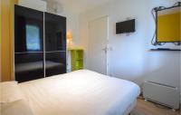 a bedroom with a bed and a tv on the wall at Awesome Apartment In quemauville With Outdoor Swimming Pool, Heated Swimming Pool And 1 Bedrooms in Équemauville
