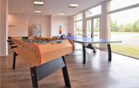 two ping pong tables in a room with windows at Awesome Apartment In quemauville With Outdoor Swimming Pool, Heated Swimming Pool And 1 Bedrooms in Équemauville