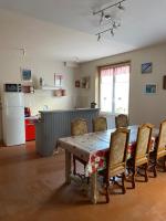 a dining room with a table and chairs and a kitchen at Le Moulin du Modon in Couffy