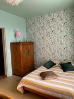 a bedroom with a bed and a wall with a wallpaper at Le Moulin du Modon in Couffy