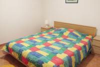 a bed with a colorful comforter in a bedroom at Apartments by the sea Cres - 8095 in Cres