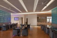 康提Radisson Hotel Kandy的一间设有桌椅的用餐室和墙上的标志