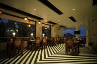 um restaurante com mesas e cadeiras em um chão listrado em Oakhill Resorts em Solan