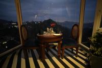 uma mesa e cadeiras em uma sala com janela em Oakhill Resorts em Solan