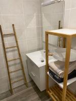 a bathroom with a sink and a shelf with towels at Studio rénové 200 m de la plage avec parking privé in Cap d&#39;Agde