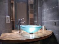 a bathroom with a blue bowl sink on a wooden counter at Passage du Cygne in Blois
