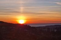 a sunset with the sun setting over the ocean at Beautiful Sea View House in Vallauris