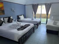 a hotel room with two beds and a balcony at Samui Green Hotel in Chaweng
