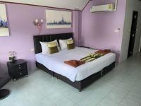 a bedroom with a large bed with purple walls at Samui Green Hotel in Chaweng