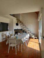 a dining room with a table and chairs and a staircase at Calme et lumière à 2 pas de la mer in Plouescat