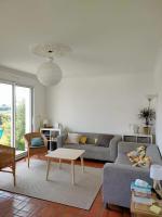 a living room with a couch and a table at Calme et lumière à 2 pas de la mer in Plouescat