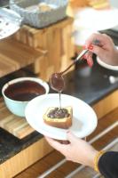 ibis Sao Jose dos Campos Dutra في ساو جوزيه دوس كامبوس: شخص يأكل قطعة من الكعكة بالملعقة