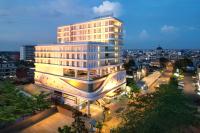 Un edificio iluminado en una ciudad por la noche. en Golden Tulip Pontianak, en Pontianak