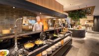 a kitchen with a chef preparing food in a restaurant at Onn Yuda Onsen in Yamaguchi