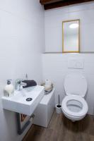 a bathroom with a white toilet and a sink at La couronne Maison 80m2 garage &amp; terrasse in Sainte-Croix-en-Plaine