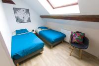 a room with two beds and a chair in it at La couronne Maison 80m2 garage &amp; terrasse in Sainte-Croix-en-Plaine