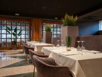 a row of tables in a room with chairs and windows at Hotel Minerva in Arezzo