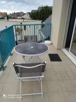 a table and a chair on a balcony at Appartement bord de mer in La Turballe