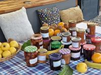 een tafel met potten jam en fruit erop bij Au Gré Des Lis in Belval-sous-Châtillon