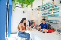 Een man en een vrouw zitten aan een bar drankjes te bereiden. bij The Voyage - Cafe Hostel CoWork in Pune