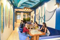 een groep mensen die aan een tafel in een restaurant zitten bij The Voyage - Cafe Hostel CoWork in Pune