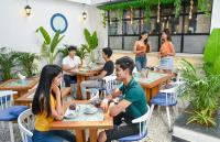 een groep mensen die aan tafels in een restaurant zitten bij The Voyage - Cafe Hostel CoWork in Pune