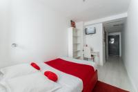 a bedroom with a bed with red pillows on it at L&#39;Oasis Montparnasse in Paris