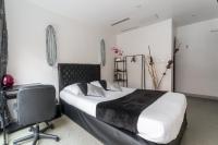 a bedroom with a bed and a desk and a chair at L&#39;Oasis Montparnasse in Paris
