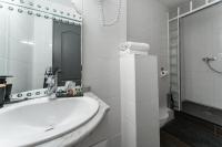 a white bathroom with a sink and a shower at L&#39;Oasis Montparnasse in Paris