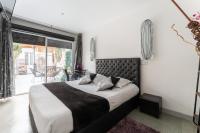 a bedroom with a large bed and a balcony at L&#39;Oasis Montparnasse in Paris