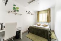 a bedroom with a bed and a desk and a window at L&#39;Oasis Montparnasse in Paris