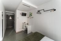 a bedroom with a bed and a desk and a tv at L&#39;Oasis Montparnasse in Paris