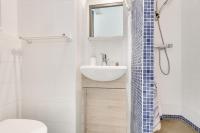 a white bathroom with a sink and a toilet at L&#39;Oasis Montparnasse in Paris