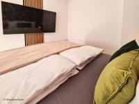 a bedroom with a bed with a tv on the wall at St. Antoni Suite 2 in Eisenstadt