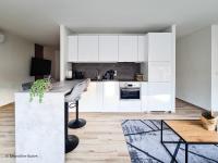 a kitchen with white cabinets and a table at St. Antoni Suite 2 in Eisenstadt