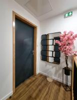 a hallway with a black door and a vase with pink flowers at Résidence Pompidou Libourne in Libourne