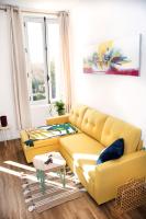 a living room with a yellow couch and a table at Résidence Pompidou Libourne in Libourne